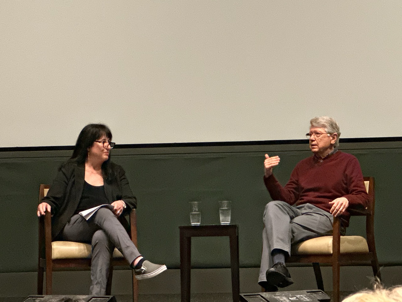 Patrice Petro, Dick Wolf Director of the Carsey-Wolf Center, discusses Trouble in Paradise with emeritus Professor of Film and Media Studies Charles Wolf. They are seated in armchairs, and Wolfe is gesturing as he makes a point about the film.